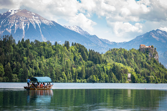 Tourists enjoying beautiful views from the Bled lake while sitting in their canoe - Image of Yacht R